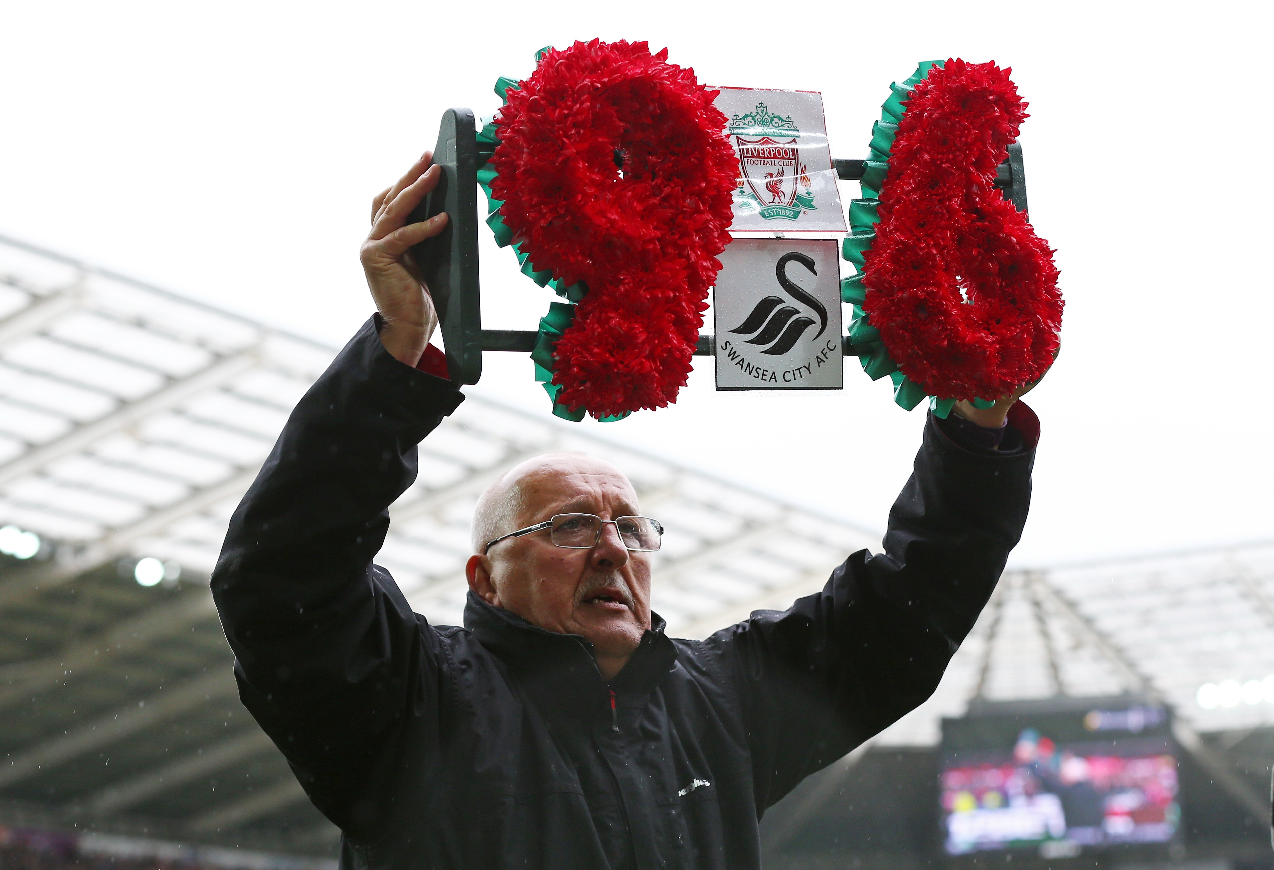 SWANSEA, WALES - MAY 01: Barry Devonside, father of Hillsborough victim Christopher Devonside carries a wreath as the team's remember the 96 victims of the Hillsborough disaster during the Barclays Premier League match between Swansea City and Liverpool at The Liberty Stadium on May 1, 2016 in Swansea, Wales. (Photo by Steve Bardens/Getty Images)