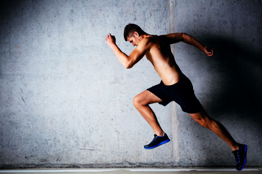 Runner sprinting against concrete wall