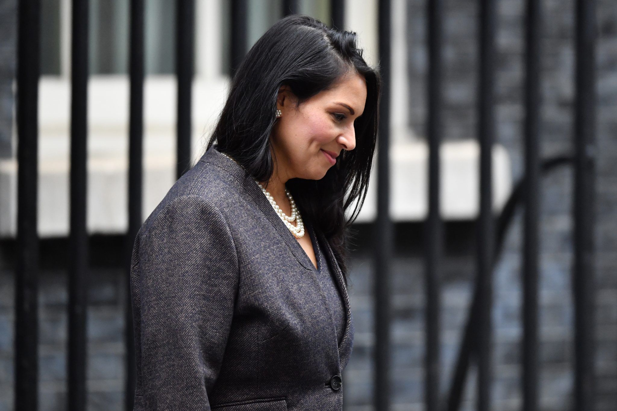 Priti Patel looking down smiling while leaving Number 10 Downing Street