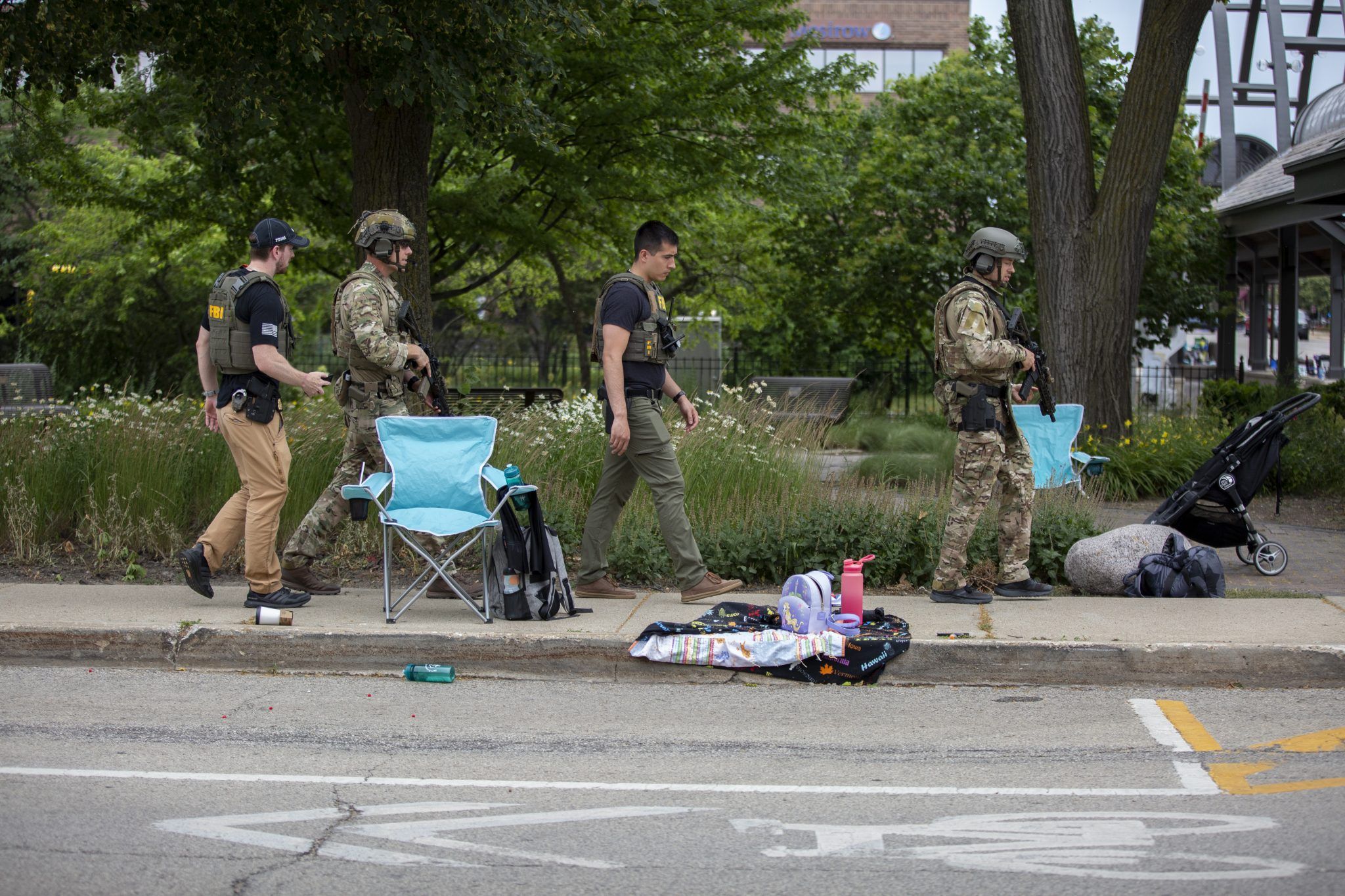 HIGHLAND PARK, IL - JULY 04: Law enforcement works the scene after a mass shooting at a Fourth of July parade on July 4, 2022 in Highland Park, Illinois. Reports indicate at least six people were killed and more than 20 injured in the shooting. (Photo by Jim Vondruska/Getty Images)