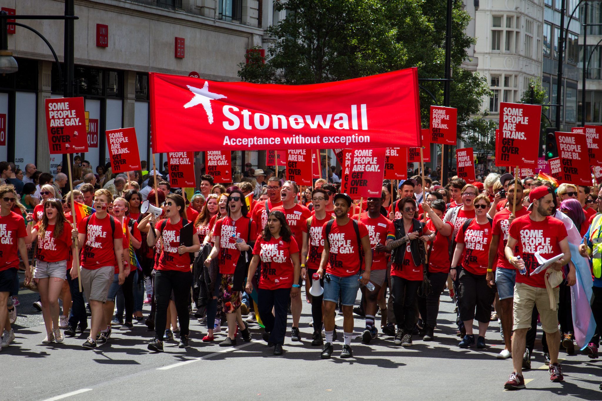 People supporting the organization Stonewall which works for the equality and justice for lesbians, gay men and bisexuals, during the Pride London on the 27th July 2015. People wear banners and t-shirts with the text "Some people are gay, get over it"